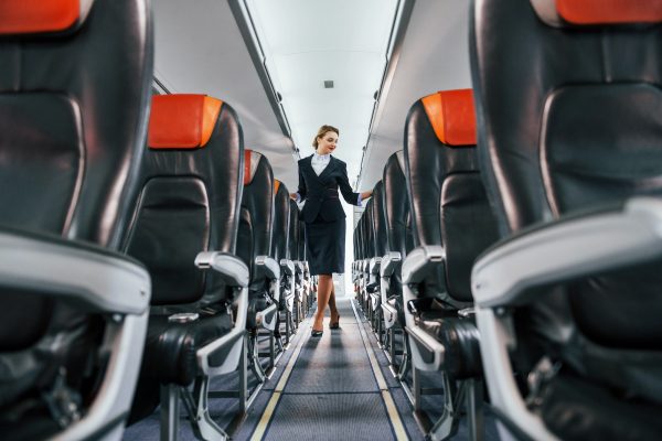 Empty seats. Young stewardess on the work in the passanger airplane