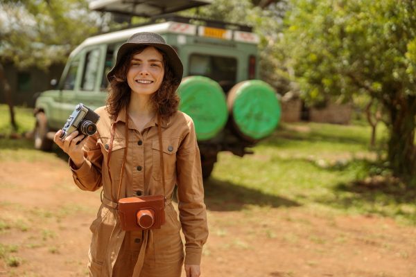 Happy woman on safari using photo camera