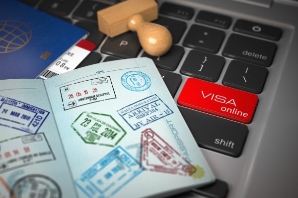 Visa online application concept. Open passport with visa stamps